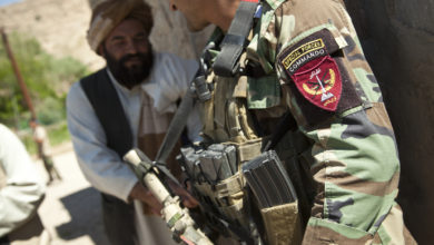 An Afghan National Army special forces soldier, right, talks with a potential Afghan Local Police candidate in Helmand province, Afghanistan