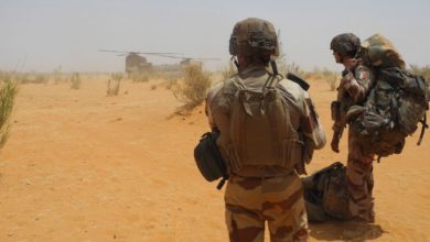 Two French soldiers wait to board a helicopter in east-central Mali.