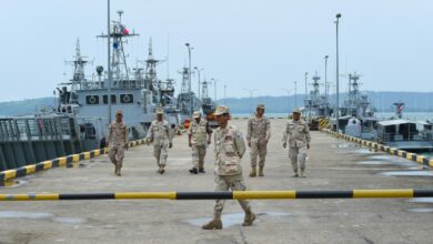 Cambodian navy personnel walk on a jetty at the Ream naval base during a government-organized media tour in July, 2019