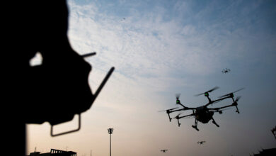 Photo of a man flying a drone.