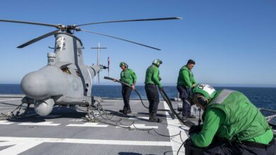 Sailors charge the battery of an MQ-8B Fire Scout unmanned aerial vehicle aboard Independence-variant littoral combat ship USS Charleston