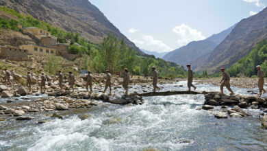 Anti-Taliban fighters crossing a river in the Panjshir valley