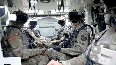 American soldiers wearing the Integrated Visual Augmentation System (IVAS) goggles while inside a Stryker.