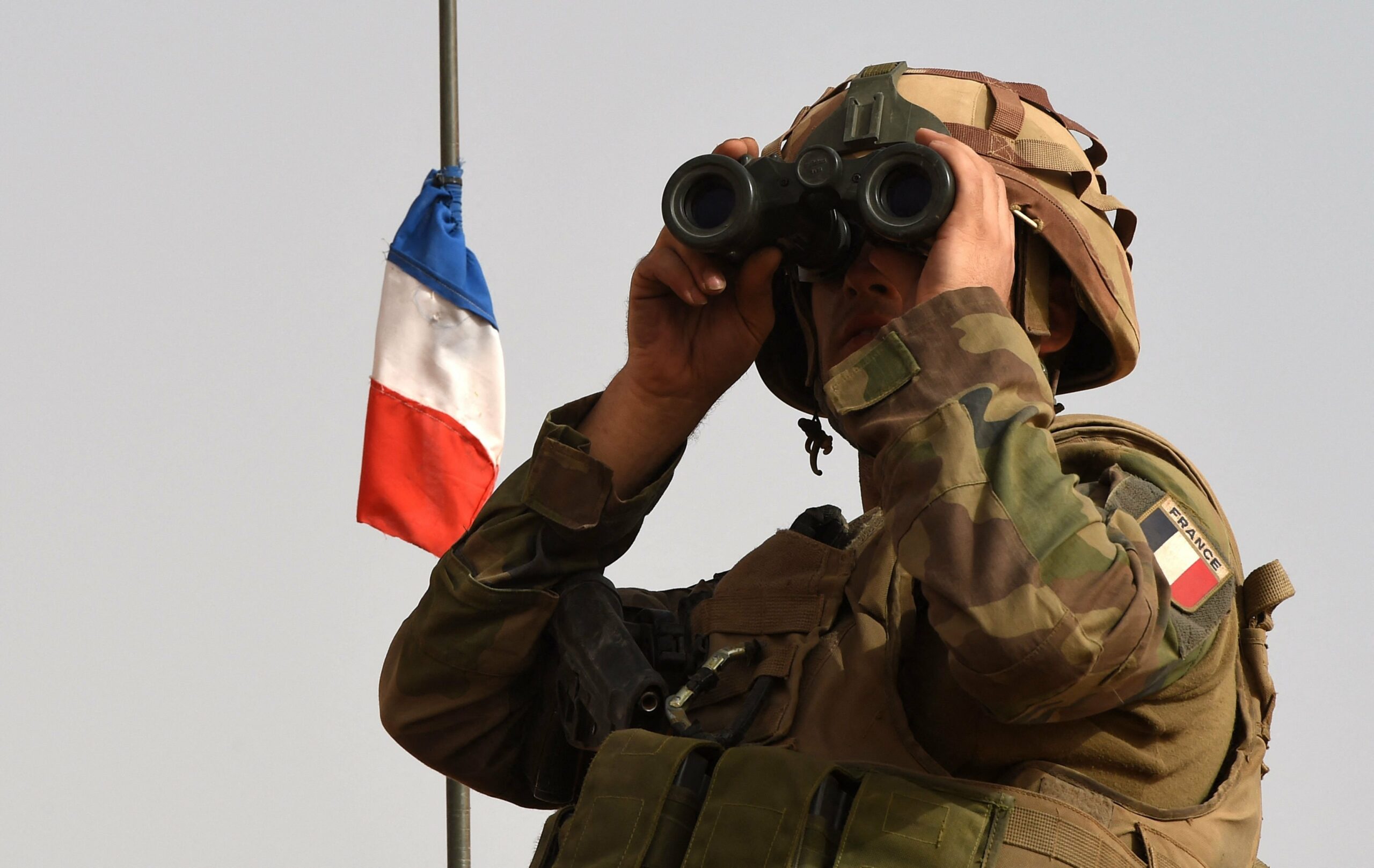 A French soldier looks through binoculars