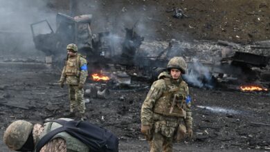 Ukrainian service members look for and collect unexploded shells after a fighting with Russian raiding group in the Ukrainian capital of Kyiv