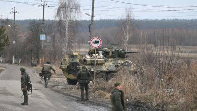 Ukrainian servicemen stand near an armored personnel carrier BTR-3