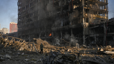 A man stands looking at the burning and destroyed Retroville shopping mall