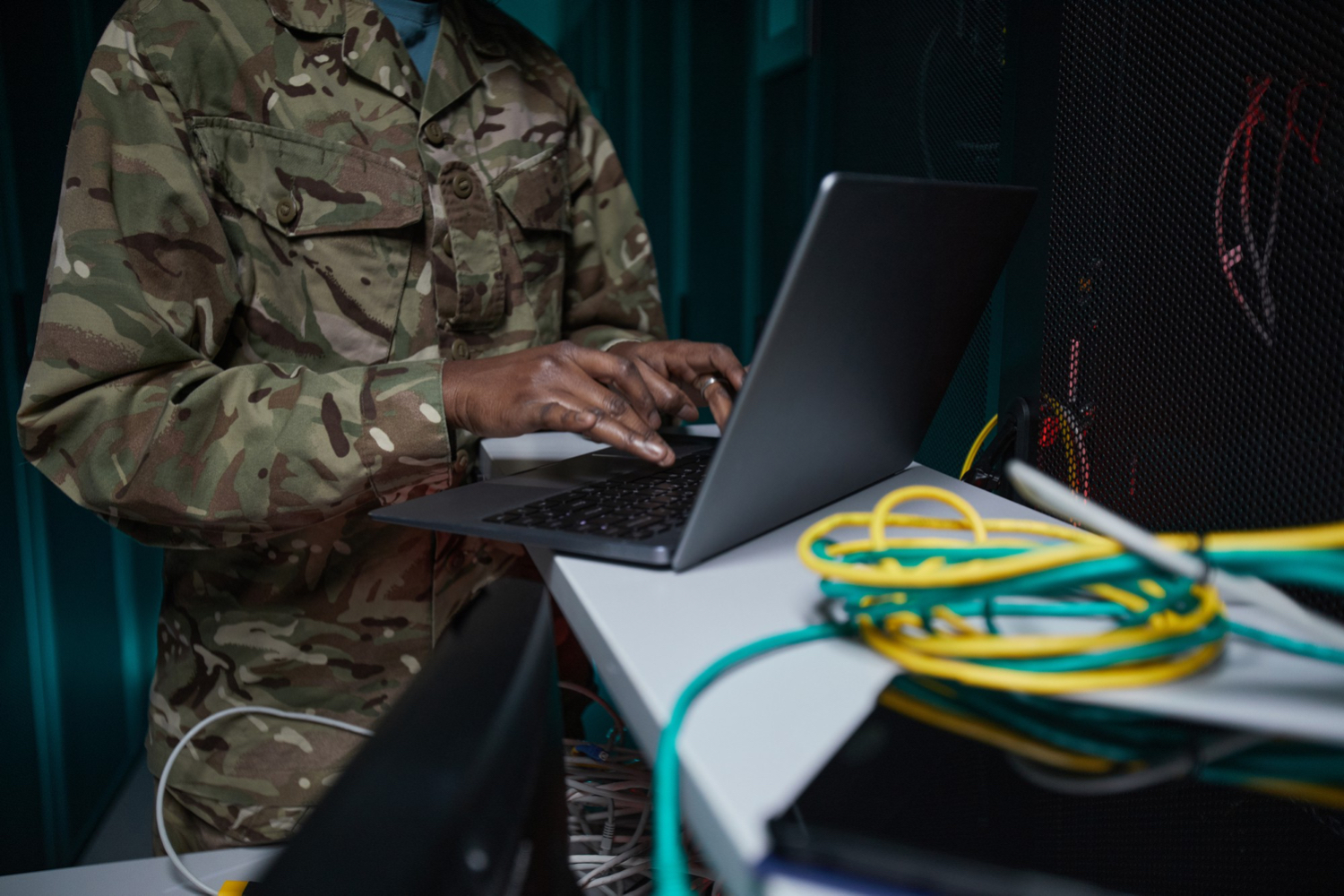 Soldier using laptop in computer server room