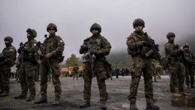 NATO soldiers serving in Kosovo patrol next to a road barricade set up by ethnic Serbs near the town of Zubin Potok