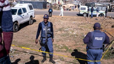 South African Police Service (SAPS) officers enforce a perimeter around a crime scene in South Africa