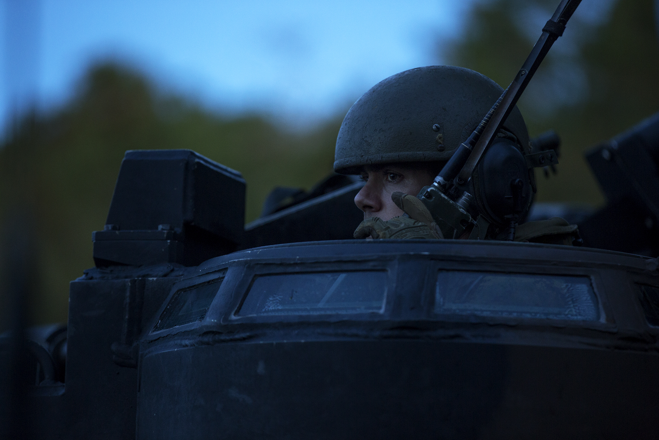 A marine communicates over a radio in an amphibious assault vehicle.