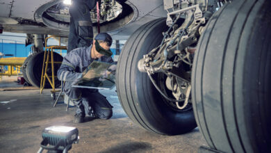 Personnel conducting aircraft maintenance using augmented reality goggles.