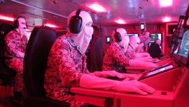 Singaporean armed forces in ship control room at sea.