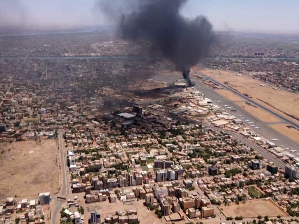 An aerial view shows black smoke rising above the Khartoum International Airport in Khartoum, Sudan