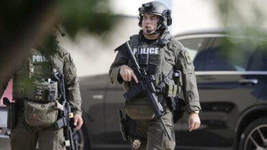 A member of the Allen SWAT team returns to the scene of a shooting in Allen, Texas, May 6, 2023