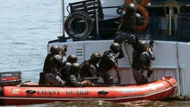 Philippine and Japanese Coast Guard personnel conduct a drill as they board a Philippine Coast Guard boat during their annual anti-piracy exercise in the waters off Manila Bay