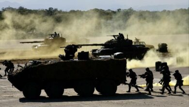 Taiwanese soldiers stay behind armed vehicles during a drill at the Hsinchu military base in 2021