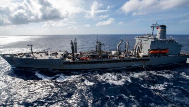 SOUTH CHINA SEA (April 24, 2020) Amphibious assault ship USS America (LHA 6) sails alongside fleet replenishment oiler USNS Pecos (T-AO 197) during a replenishment-at-sea. America, flagship of the America Expeditionary Strike Group, 31st Marine Expeditionary Unit team is operating in the U.S. 7th Fleet area of operations to enhance interoperability with allies and partners and serve as a ready response force to defend peace and stability in the Indo-Pacific region. (U.S. Navy photo by Mass Communication Specialist 3rd Class Jomark A. Almazan)