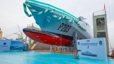 The new Nigerian Navy offshore patrol vessel, P203, is seen in a shipyard in Istanbul, Turkey. A rope of balloons decorate its deck's perimeter and a sign that says "LAUNCHING CEREMONY OF NIGERIAN ARMY HE 76M OFFSHORE PATROL VESSEL NO. 1 (P203)" is seen erected on the ground. The ship's grey hull has the name P203 painted in black, on the left.