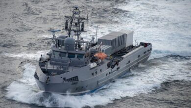 Ranger, a US Navy unmanned surface vessel, is seen sailing blue-grey waters. Its hull is painted black and the word "RANGER" is painted on its hull, close to the front.