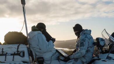 UAV operators on snowmobiles during Arctic strike.