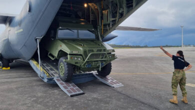 A VAMTAC ST5 4x4 vehicle being unloaded from a Super Hercules C-130J-30 aircraft