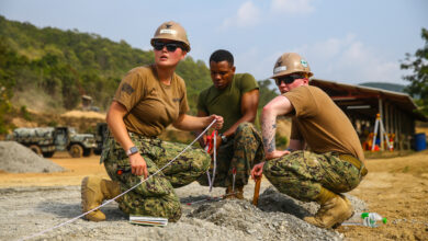 U.S. service members Petty Officer 2nd Class Megan Pringle, left, 3rd Class Jonah Foote, right, and Sgt. Emmet Marbury relay the new road measurements on Royal Thai Marine Base Sattahip, Kingdom of Thailand, Jan. 11, 2020. U.S service members and Royal Thai Marines worked together during a U.S. and Thai subject matter expert exchange to share best practices, increase their ability to work together and build friendships. Pringle, a native of Lacey, Washington, is the lead builder with Naval Mobile Construction Battalion 5. Foote, a native of Gaylord, Michigan, is a steelworker with NMCB 5. Marbury, a native of Dallas, Texas, is the 3rd squad leader with Bravo Company, 9th Engineer Support Battalion, 3rd Marine Logistics Group. (U.S. Marine Corps photo by Cpl. Ryan Harvey)