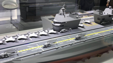 Conceptual model of a South Korean Navy aircraft carrier. The model has jet fighters and helicopters taxied on its deck. The ship is painted gray.