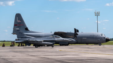 Airmen take a break in the shade after landing a C-130 cargo aircraft and refueling an F-16 fighter jet at Avon Park, Florida, June 6, 2022. Airmen nationwide participated in a week-long exercise in Jacksonville, Fla. called "Rally in the Swamp" coordinated by the 22nd Air Force. (U.S. Air Force photo by Staff Sgt. Timothy Leddick) (This photo has been edited to enhance the subjects)