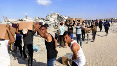 Local residents receive supplies and walk through the destroyed town in Rafah, the southernmost part of Gaza Strip, on May 29, 2025. The distribution of aid led by Israel and United States of America began in Rafah, on the same day. Crowds rushed to the site, and according to the Middle Eastern satellite television station Al Jazeera, at least three people were killed and 46 were injured by Israeli gunfire. ( The Yomiuri Shimbun ) (Photo by YOMIURI SHIMBUN / Yomiuri / The Yomiuri Shimbun via AFP)