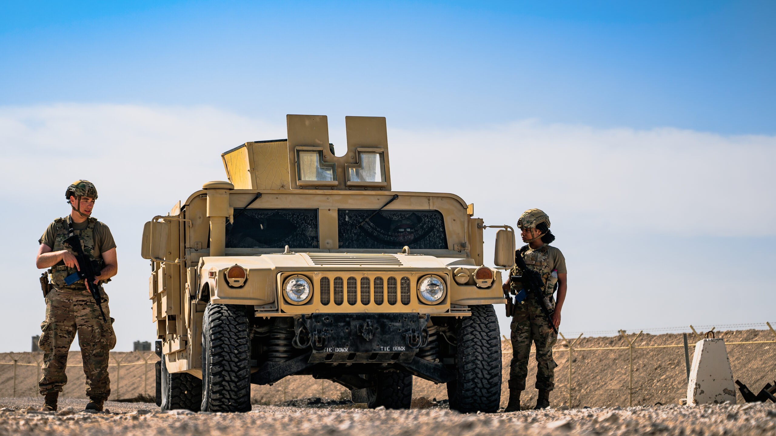 U.S. Air Force Airman 1st Class Dane Brouillette and Airman 1st Class Alyssa Richardson, 379th Expeditionary Security Forces Squadron installation patrollers, exit a Humvee during a Tactical Leadership Course within the U.S. Central Command area of responsibility, Jan. 20, 2025. Airmen were evaluated on their ability to respond effectively to simulated attacks or security incidents within the installation. (U.S. Air Force photo by Airman 1st Class Zeeshan Naeem)