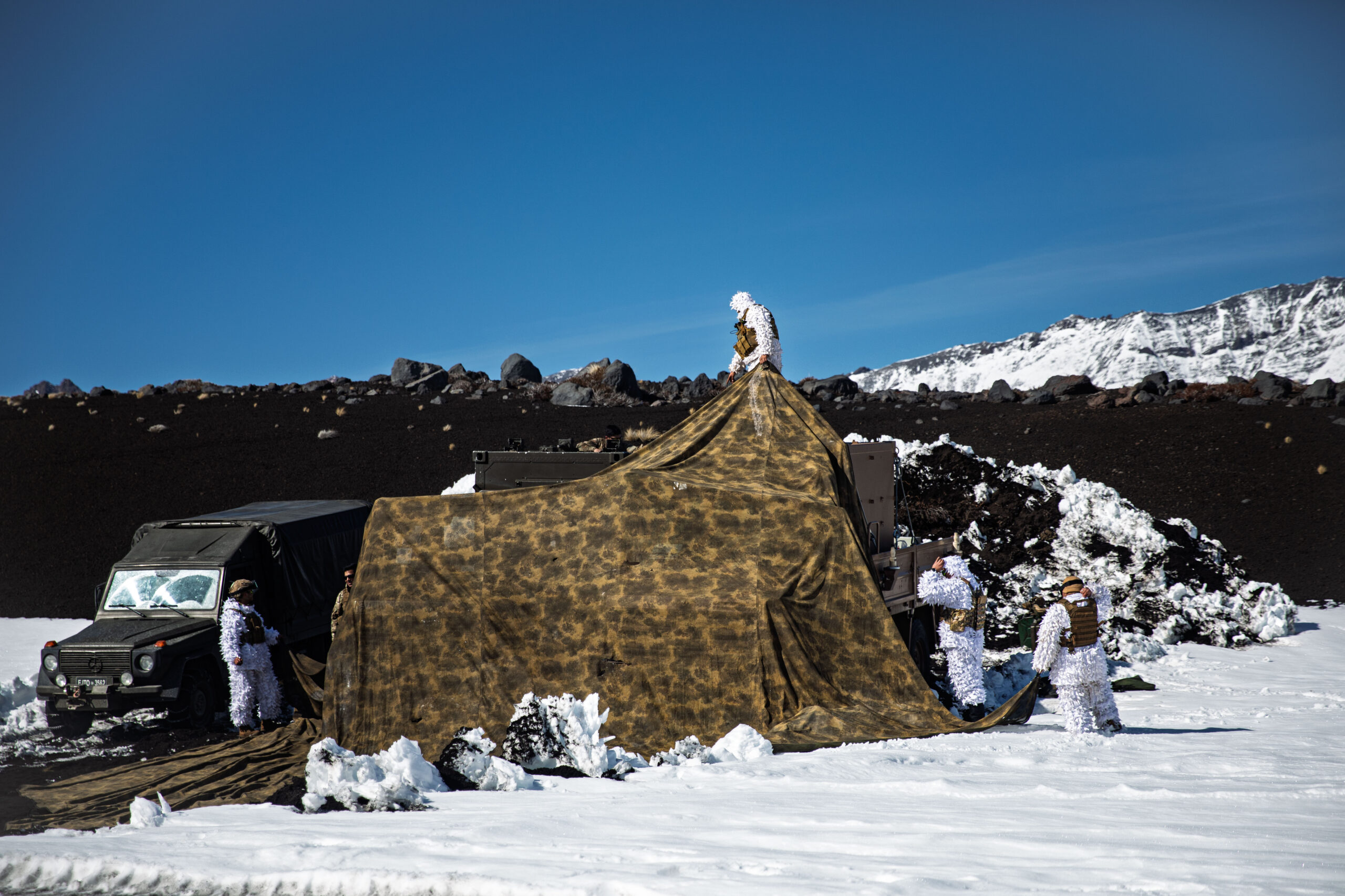 Chilean soldiers erect a tent to shield a vehicle from adverse weather during Exercise Southern Vanguard 25, in Antuco, Chile, Aug. 25, 2025. Exercise Southern Vanguard 25 underscores the U.S. Army’s enduring commitment to regional partnerships as U.S. forces deploy to Chile to conduct combined mountain warfare, field, and command post training alongside Chilean forces. Argentina and Peru are also participating—strengthening interoperability, shared readiness, and mutual trust while advancing regional security and cooperation across the Western Hemisphere. (U.S. Army National Guard photo by Sgt. Jean Sanon)