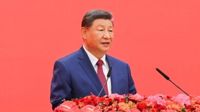 Chinese President Xi Jinping in front of a red background at a commemoration event