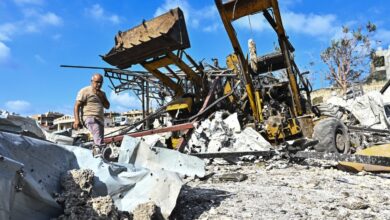 A man walking across rubble in Lebanon after an Israeli strike.