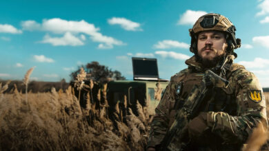 Soldier with a laptop on the battlefield