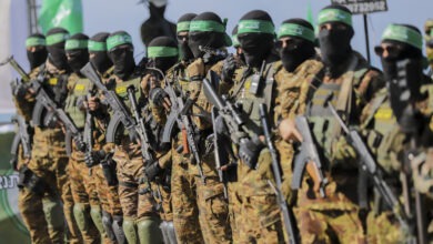 Palestinian militant group Hamas fighters secure an area before handing over an Israeli-America hostage to a Red Cross team in Gaza City on February 1, 2025, as part of the fourth hostage-prisoner exchange. Ranks of Hamas fighters formed up on Gaza's beachfront on February 1 for the handover of an Israeli-American hostage Keith Siegel in a show of force against the dramatic backdrop of breaking waves. (Photo by Saeed Jaras / Middle East Images via AFP)