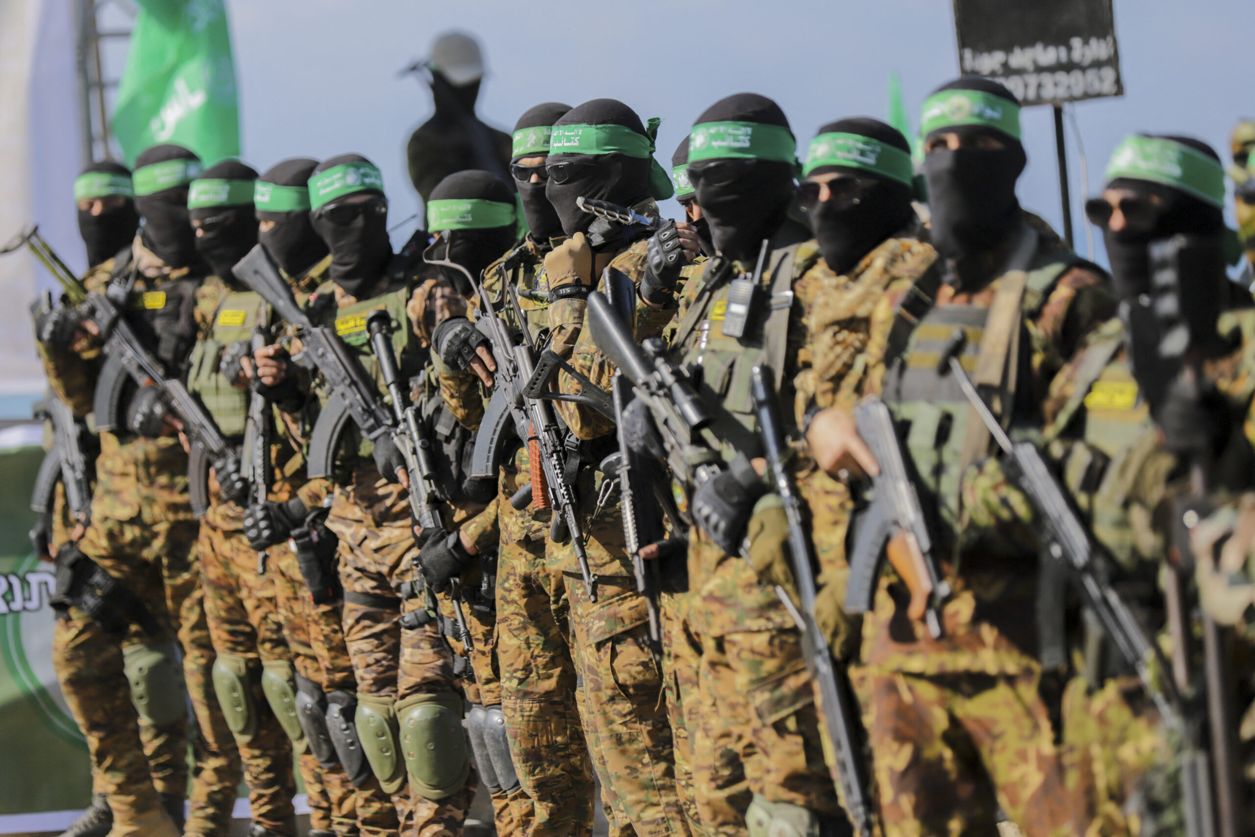 Palestinian militant group Hamas fighters secure an area before handing over an Israeli-America hostage to a Red Cross team in Gaza City on February 1, 2025, as part of the fourth hostage-prisoner exchange. Ranks of Hamas fighters formed up on Gaza's beachfront on February 1 for the handover of an Israeli-American hostage Keith Siegel in a show of force against the dramatic backdrop of breaking waves. (Photo by Saeed Jaras / Middle East Images via AFP)