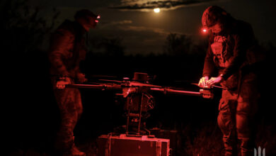 Troops setting up a drone at night