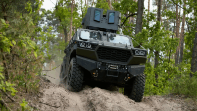 The Inguar-3 armored vehicle driving through a soil pathway with a forest background