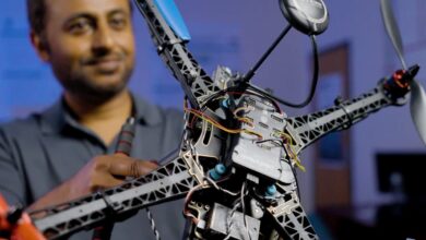 A researcher holding the SHIELD drone inside a dim room