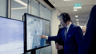 Pete Hegseth interacts with a touchscreen command-and-control system displaying real-time aerial surveillance data during a demonstration.