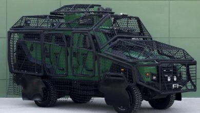 A well lit image of the Jedi armored vehicle covered by the Q-Net system in front of a green wall background