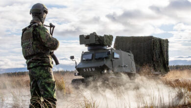 Soldier in front of a GTT all-terrain vehicle