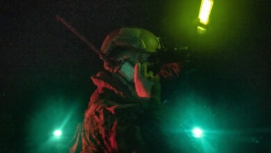 A U.S. Marine with Battalion Landing Team 2/5, 31st Marine Expeditionary Unit, listens to a radio and signals during a night casualty evacuation exercise aboard USS New Orleans (LPD 18) in the Sea of Japan, Sept. 12, 2022. The 31st MEU is operating aboard ships of the Tripoli Amphibious Ready Group in the 7th fleet area of operations to enhance interoperability with allies and partners and serve as a ready response force to defend peace and stability in the Indo-Pacific Region. (U.S. Marine Corps photo by Sgt. Danny Gonzalez)
