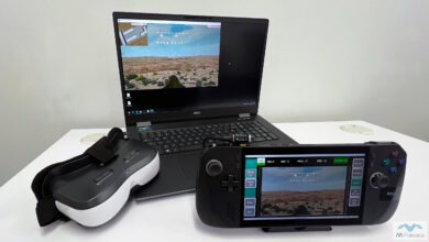 A laptop with a VR headset and game controller, set up for an FPV simulator experience.