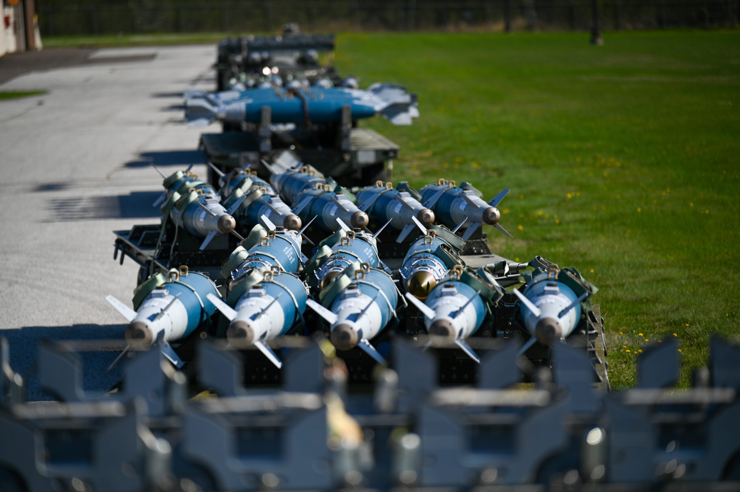 Inert GBU-38 bombs sit on a palate ready to be loaded onto an F-16 Fighting Falcon
