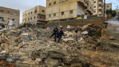 A man and a boy sit in the rubble of the home of the family of Imran al-Atrash, demolished by Israeli forces during a raid in Hebron’s Khallat Nafisa area in West Bank