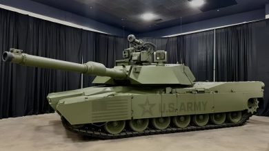 M1E3 Abrams main battle tank displayed indoors, showing its upgraded turret, long main gun, reinforced armor, and U.S. Army markings under exhibition lighting.