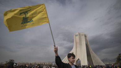 A young Iranian man waves a flag of Lebanon's Hezbollah while standing in front of the Azadi (freedom) monument during a rally commemorating the 47th anniversary of the Islamic Revolution's victory in Tehran, Iran, on February 11, 2026.