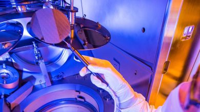 Personnel lifting a thin-film lithium niobate (TFLN) wafer
